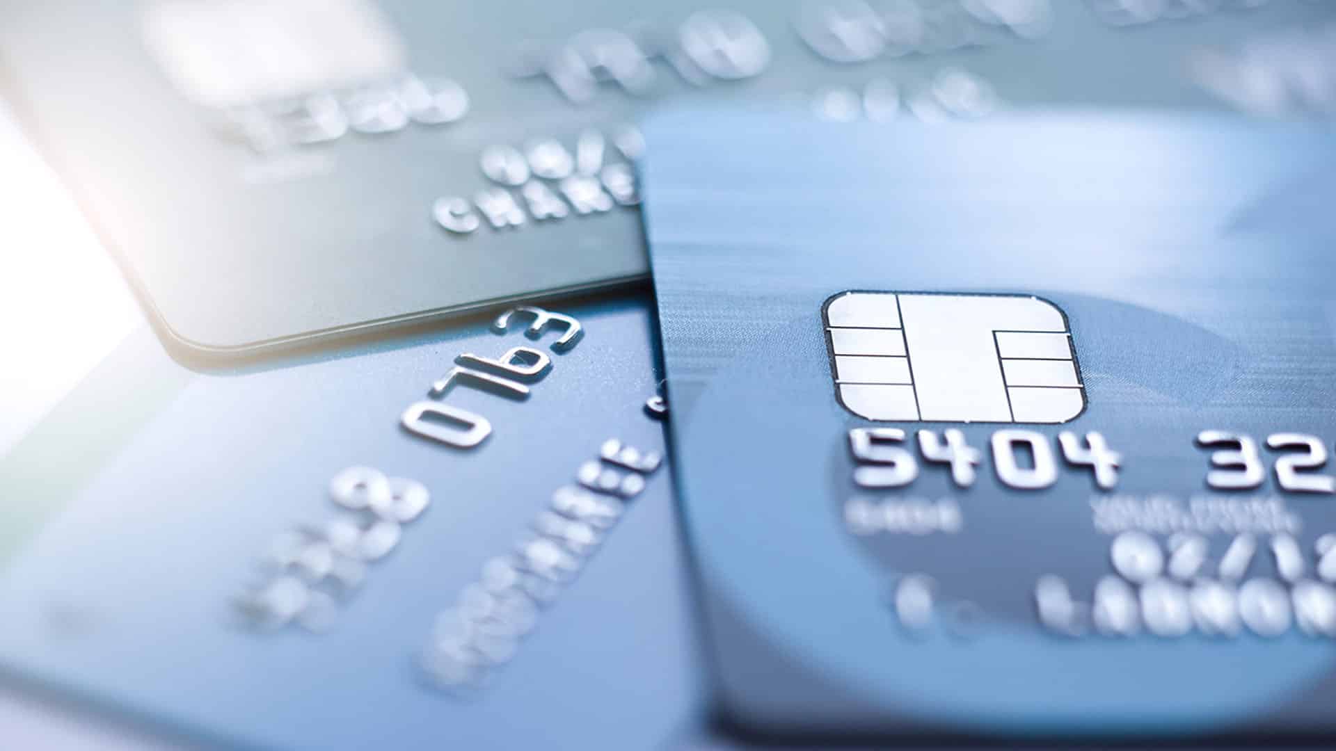 Gros plan de cartes bancaires bleues avec puces électroniques et numéros embossés