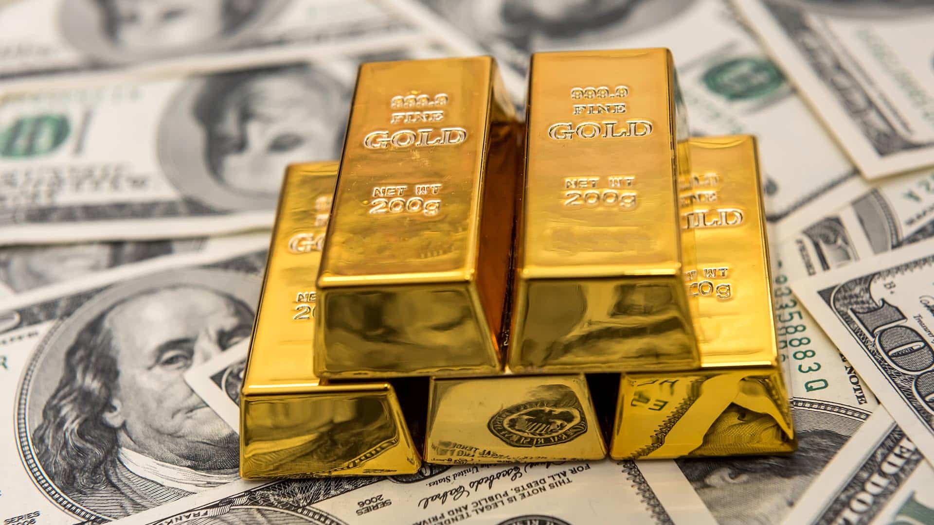 Lingots d'or pur 200g posés sur des billets de dollars américains, symbolisant l'échange de devises et les métaux précieux