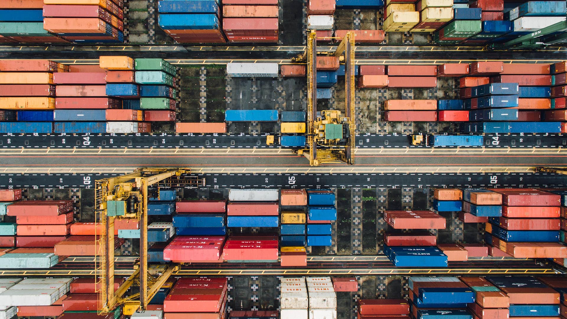 Vue aérienne d'un port avec conteneurs d'expédition colorés et grues de chargement