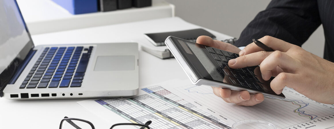 Professionnel calculant des taux de change CHF/EUR avec calculatrice, laptop et documents financiers sur son bureau