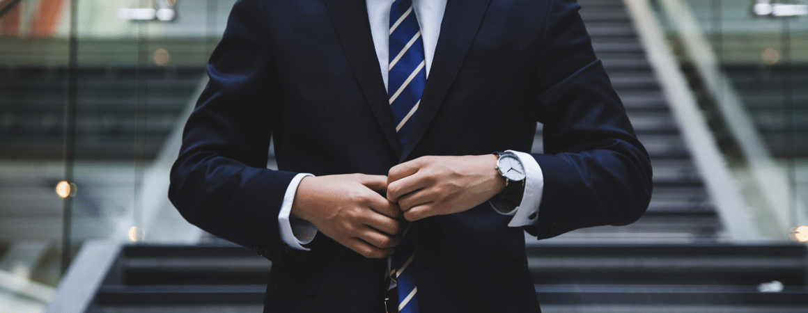 Homme d'affaires en costume bleu marine et cravate rayée dans un cadre professionnel feutré