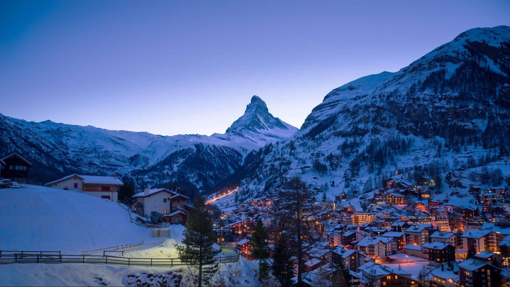 Vue nocturne de Zermatt en hiver avec le Cervin enneigé et les chalets illuminés en Suisse valaisanne