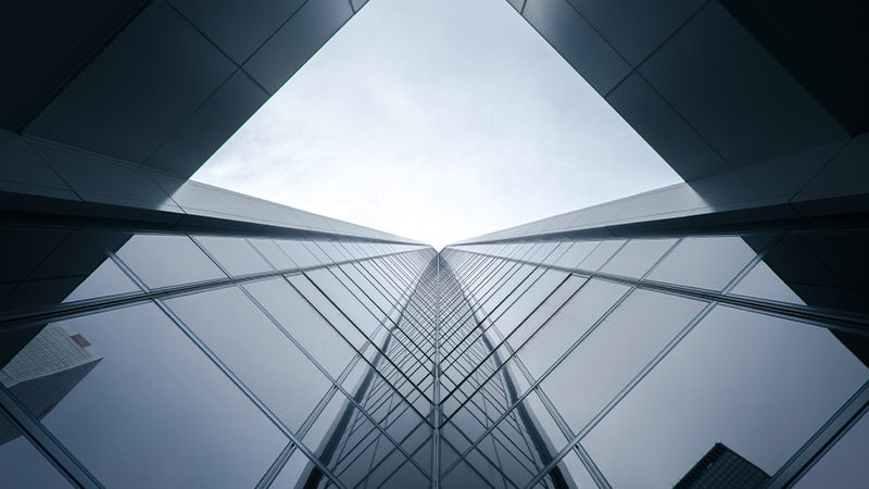Façade de gratte-ciel moderne en verre et acier avec perspective symétrique vers le ciel