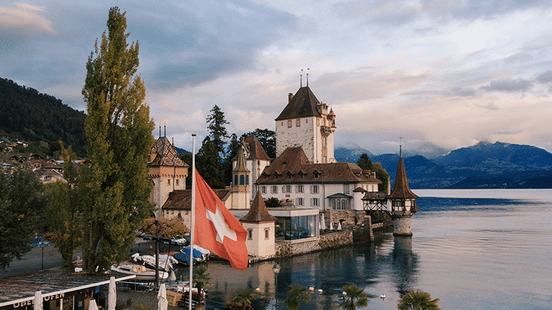 Château de Chillon avec drapeau suisse au bord du lac Léman, Suisse romande